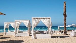 A beach with white canopies and lounge chairs. - Cleopatra Sidi Heneish (Marsa Matrouh)