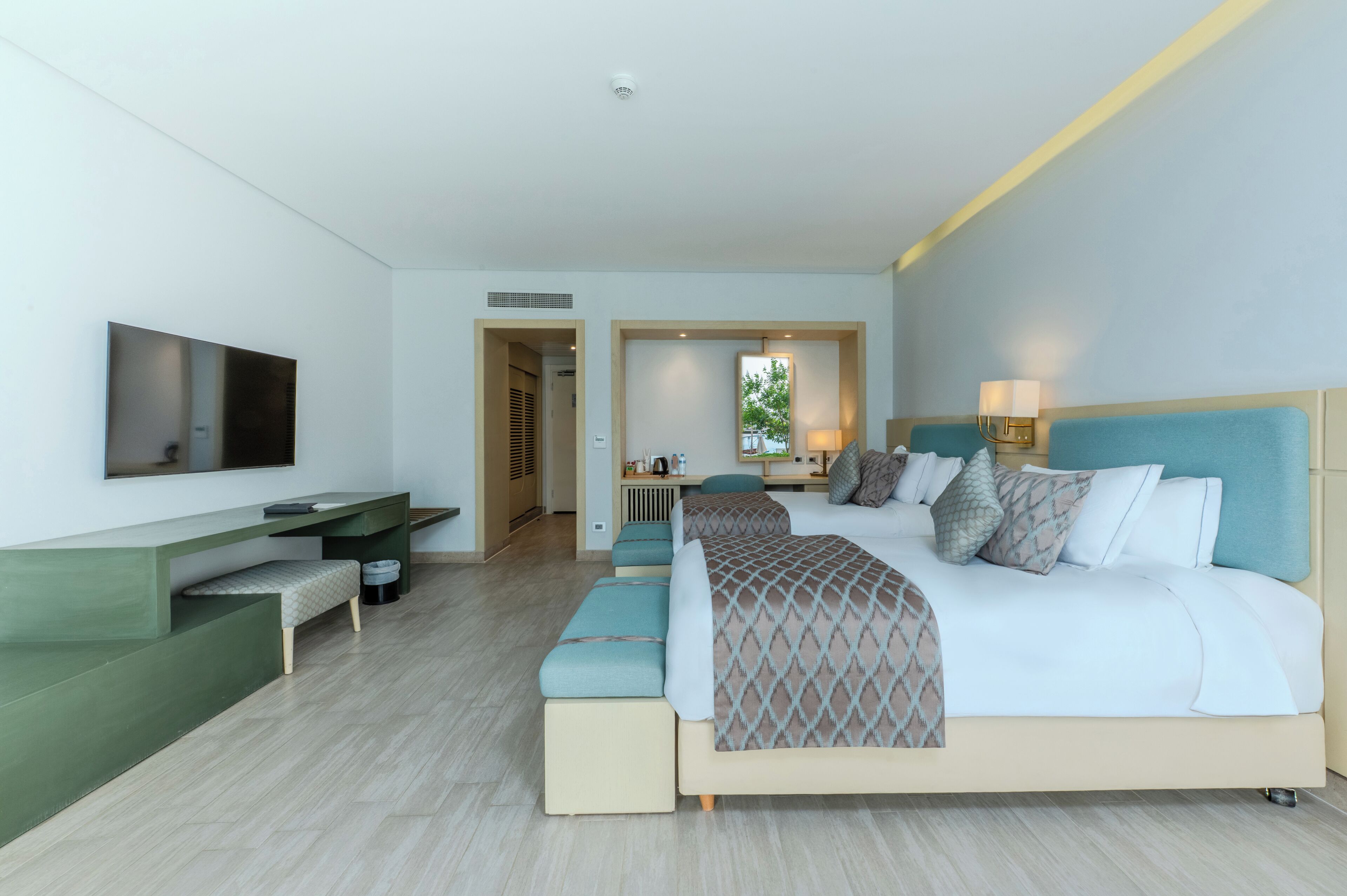 Een moderne hotelkamer met een groot bed, een bureau en een aan de muur bevestigde televisie.