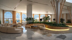 A spacious lobby with a curved seating area, large windows, and indoor plants. - Cleopatra Sidi Heneish (Marsa Matrouh)