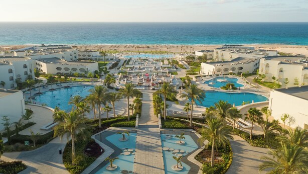 A resort with multiple swimming pools, palm trees, and a beach view. - Cleopatra Sidi Heneish (Marsa Matrouh)
