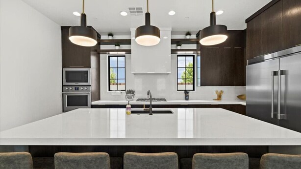 A modern kitchen with a large island, stainless steel appliances, and pendant lighting. - Casa Blanca luxury Villa Private pool sleeps 30! (Hurricane)