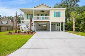 A two-story house with a covered front porch, a balcony on the upper floor, and a garage.