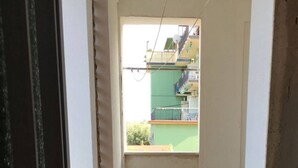 Un pasillo estrecho con suelo de baldosas que da a un balcón.