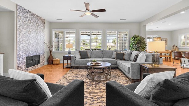 A spacious living room with a sectional sofa, a coffee table, and a fireplace. - Desert Golf Getaway by GPM -Tennis+Pickleball+Priv. Pool+More! Walk to Festivals (Indio)