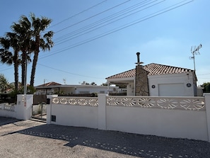 A residential property with a gated entrance, a garage, and a stone facade.