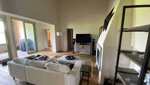 A spacious living room with a large sofa, a flat-screen TV, and a fireplace. - The Valley 3 (Castelfalfi)
