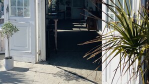 A beach club with a sign reading "Oscar's Beach Club" and a door open to the inside. - Düne 77Modern vacation apartment in Westdorf in top location (Baltrum)
