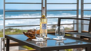Ein Tisch mit einer Flasche Protea-Wein, zwei Gläsern und einer dekorativen Muschel.