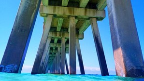 A pier structure extending into clear blue water. - Beach Vibes in Navarre (Navarre)