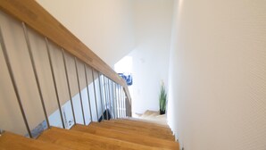 Eine Holztreppe mit Metallgeländern, die zu einer Zwischenebene führt.
