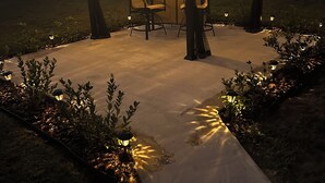Ein Pavillon mit Lichterketten, einem Tisch und Stühlen in einem Garten.