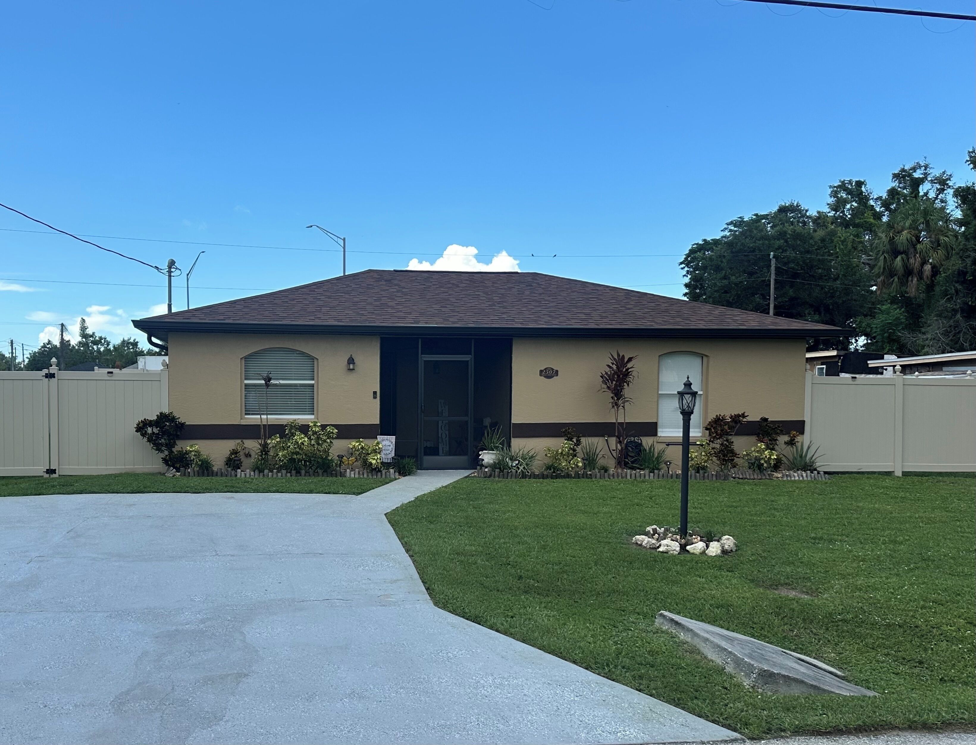 A single-story house with a front entrance, a small front yard with a pathway, and a mailbox.