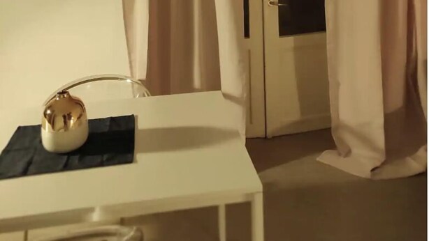 Une pièce avec une table blanche, un petit objet décoratif et une porte à panneaux de verre.