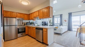 A modern kitchen with wooden cabinets, stainless steel appliances, and a central island. - Cozy 2BR condo w/ valley views (Vernon Township)
