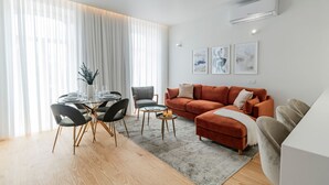 A modern living room with a glass dining table, a sofa, and a coffee table. - Almada 551 - 3.1 l Luxury Living by LovelyStay (Porto)