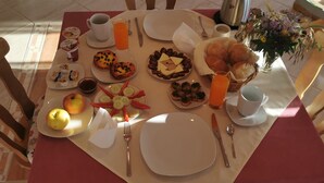 Une table mise pour le petit-déjeuner, avec des assiettes remplies de nourriture, une tasse de café et un vase de fleurs.