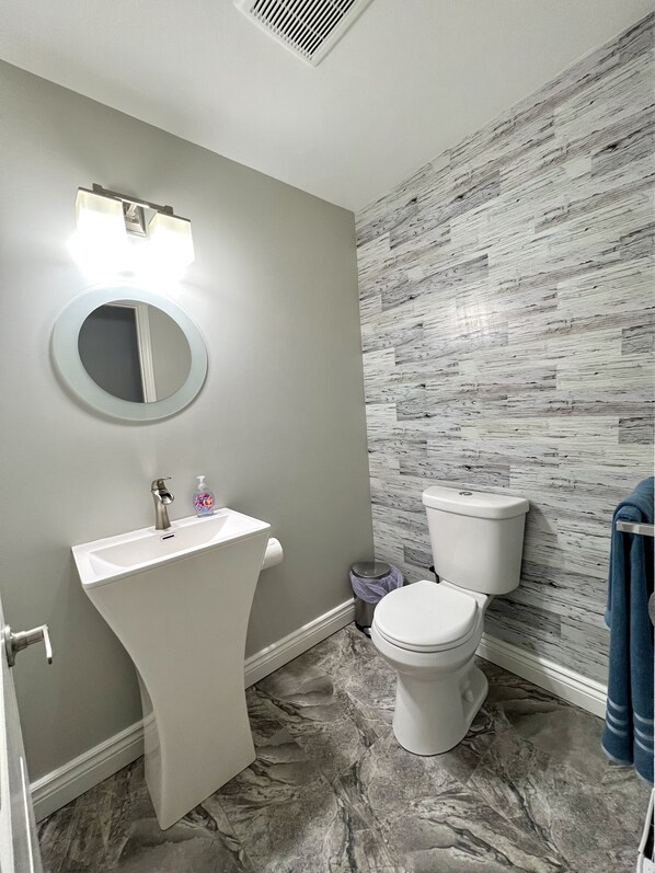 Un baño con un lavabo blanco, un inodoro y un espejo.