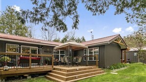 A two-story house with a deck, a covered patio, and a fenced backyard. - Lakefront cottage  (Mallorytown)
