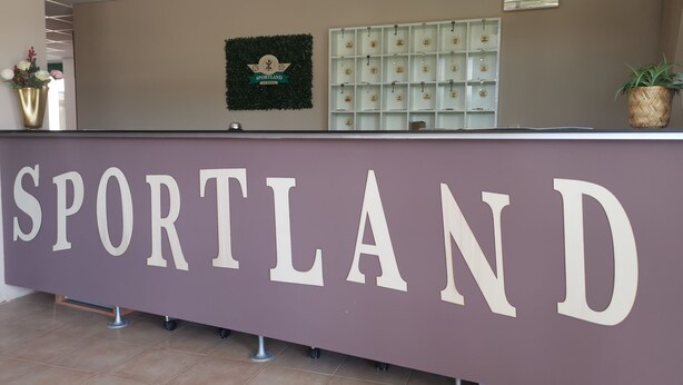 A reception desk with the word "SPORTLAND" prominently displayed. - Sportland (Colle di Val d'Elsa)