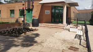 A building with a green door, a white awning, and a sign indicating it is a public facility. - Sportland (Colle di Val d'Elsa)
