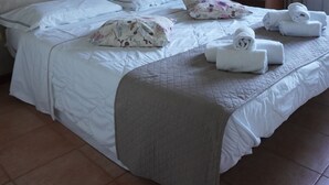 A hotel room with a large bed, a headboard, a bedside table, and a wall-mounted artwork. - Sportland (Colle di Val d'Elsa)