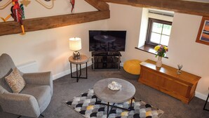A living room with a grey sofa, a coffee table, a TV, and a wooden cabinet. - The Studio at Malt Kiln Cottage (Grizebeck, near Kirkby-in-Furness)