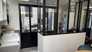 Une cuisine moderne équipée d’un évier, de placards et d’un coin repas avec une table et des chaises.