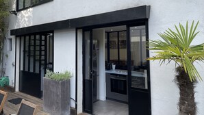Une maison moderne dotée d’une grande porte vitrée qui donne sur un espace cuisine.