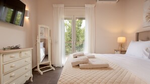 Une chambre à coucher avec un grand lit, une commode, un miroir, une table de chevet avec une lampe et une fenêtre avec des rideaux.