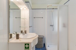 Een bad, een haardroger, handdoeken, toiletpapier