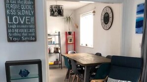 Un comedor con una mesa y sillas de madera, un aparador de vidrio y una pared con citas inspiradoras.
