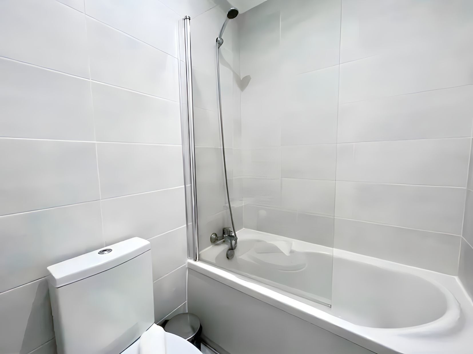 Une salle de bain moderne avec une douche à parois de verre, des toilettes blanches et une baignoire.