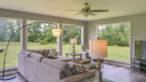 A living room with a gray sofa, two side tables with lamps, a ceiling fan, and a TV. - Tullahoma Vacation Rental < 8 Mi to Lynchburg! (Tullahoma)