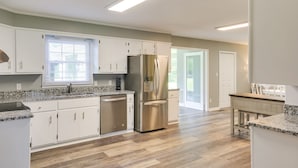 A modern kitchen with white cabinets, stainless steel appliances, and a granite countertop. - Tullahoma Vacation Rental < 8 Mi to Lynchburg! (Tullahoma)