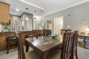 Enjoy meals in this cozy dining area with a table and six chairs, a kitchenette, and a convenient countertop with a plant.