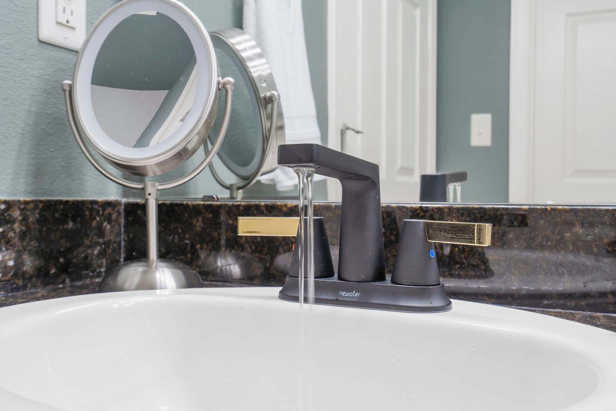 A bathroom sink with a modern faucet and a mirror.