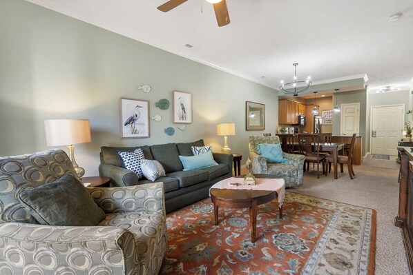 Relax in this inviting living space with a comfortable sofa, armchairs, and dining table for four.