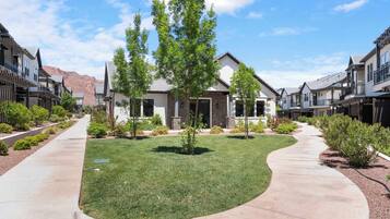 A residential area with modern houses, a curved pathway, and well-maintained lawns.