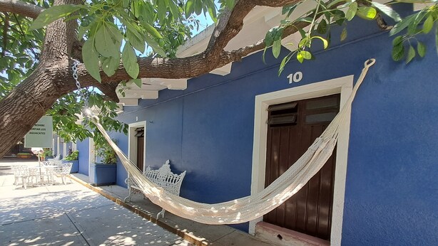 Un bâtiment bleu avec un hamac suspendu entre les portes numérotées 9 et 10.
