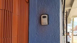 Un mur bleu avec une prise électrique en laiton et un cadenas de la marque Master Lock.