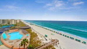 A beach resort with a swimming pool, beach umbrellas, and a view of the ocean. - SnowBirdsWelcome-GulfView-HeatedPool (Destin)