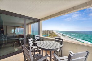 A balcony with a table and chairs, overlooking a beach and ocean. - SnowBirdsWelcome-GulfView-HeatedPool (Destin)