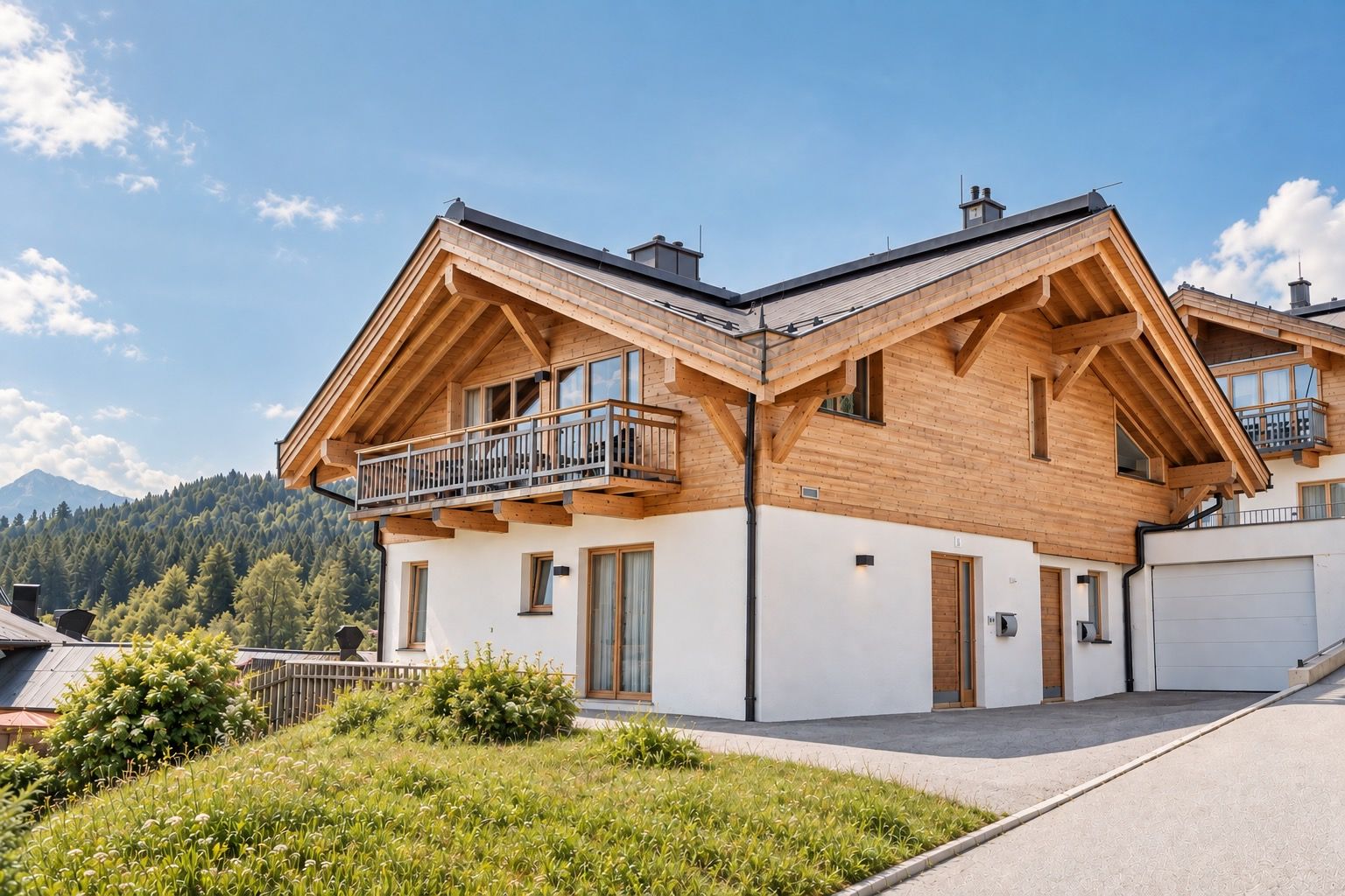 Une maison moderne à deux étages, dotée d’une façade en bois, d’un balcon et d’un garage.