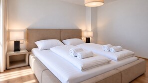 Une chambre d’hôtel avec un grand lit, deux tables de chevet et une lampe de chaque côté.