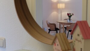 A mirror reflecting a room with a small table, chairs, and two model houses on a shelf. - Apartment "Meine Auszeit", 2 adults + 1 infant, 1 bathroom, terrace, WLAN (Koserow)