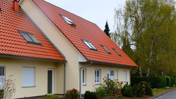 A two-story house with a red-tiled roof, a small garden, and a paved driveway. - Apartment "Meine Auszeit", 2 adults + 1 infant, 1 bathroom, terrace, WLAN (Koserow)