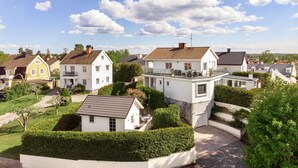 A residential area with houses, including a white house with a balcony and a yellow house. - Prinshöjden Hotel - Apartments & Villas (Katrineholm)