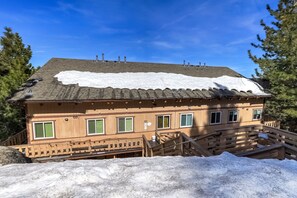 A two-story wooden building with a snow-covered roof and a wooden staircase leading to the entrance. - Mile High Mountain - Carson Valley Views (Stateline)