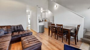 Um apartamento moderno com sala de estar, sala de jantar e cozinha.