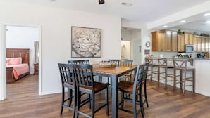 A spacious dining area with a wooden table and chairs, a ceiling fan, and a kitchen area with wooden cabinets and a microwave. - Lakefront Sanctuary II at Indian Point (Branson)